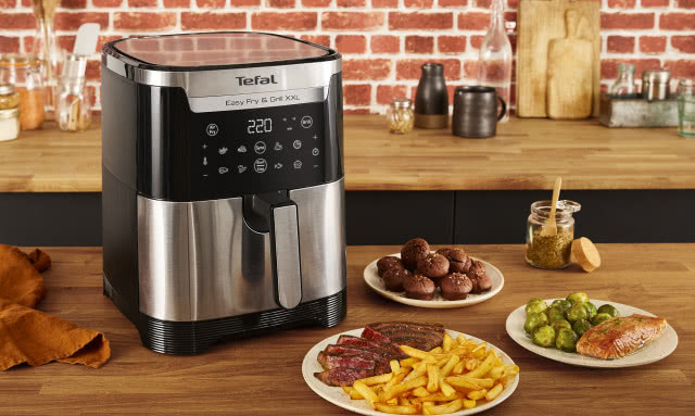 Frytownica beztłuszczowa Tefal, drewniane blaty kuchenne, cegła na ścianie, frytki, mięso, brukselka, deski do krojenia, ściereczka