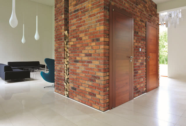 Ściana za fotelami jest wyłożona płytkami ręcznie formowanymi w kolorze 154 Douro, VANDERSANDEN