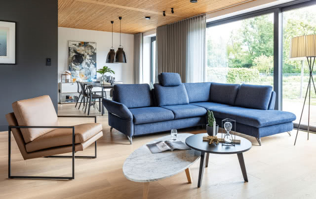 narożnik z funkcją spania, stoliki kawowe, fotel skórzany, lampa podłogowa, stół w jadalni, lampy wiszące, duże okno