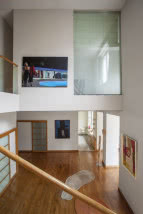 Widok ze schodów na przestrzeń otwartą domu, obrazy na ścianach