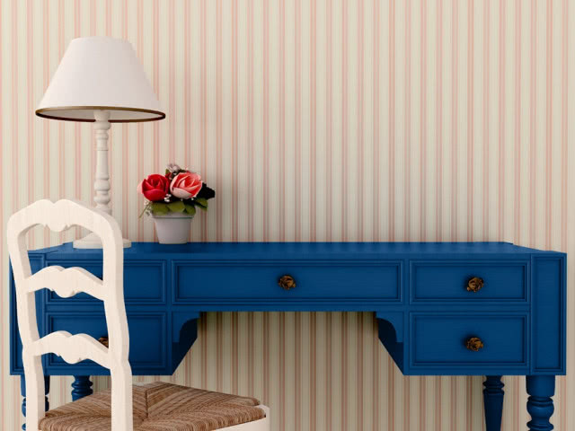 biurko na tle różowej tapety w paski