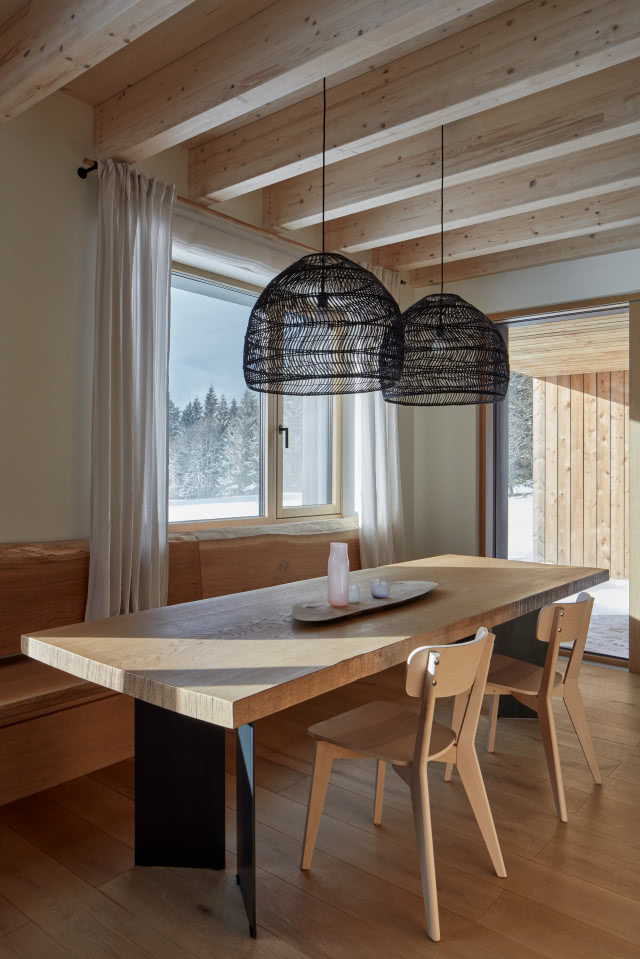 Jadalnia z drewnianym stołem i oświetleniem nad nim