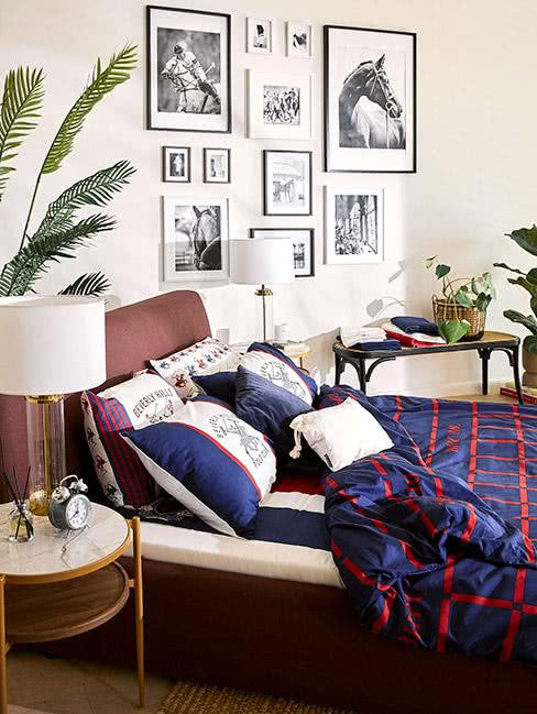 sypialnia: łóżko na tle wielu obrazków