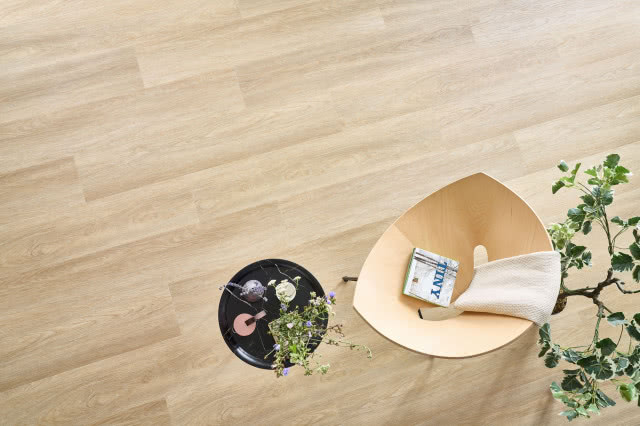 winylowe panele imitujące naturalne drewno, kwiaty, koc, książka, stolik, krzesło