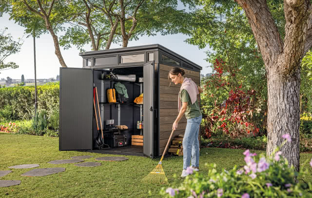 domek na narzędzia, kobieta grabi liście