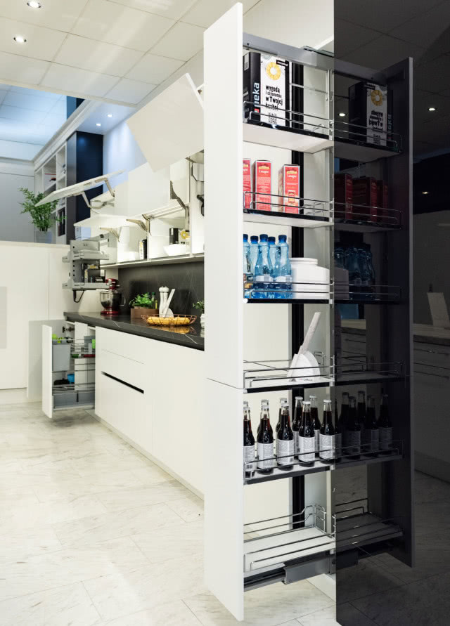 Szafki z systemem DISPENSA, białe fronty kuchenne, czarny blat,