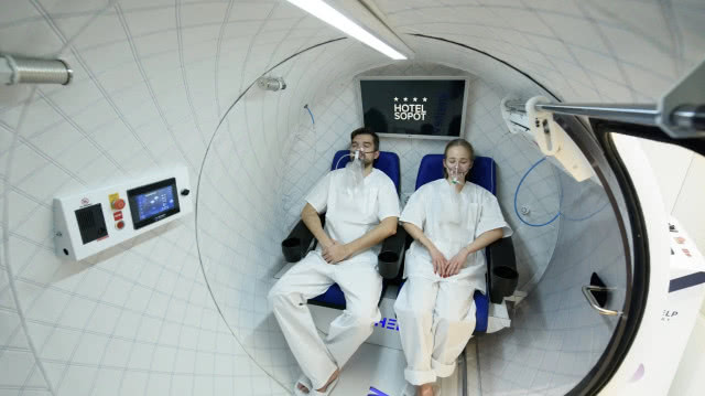 dwoje ludzi w kabinie wdychają tlen