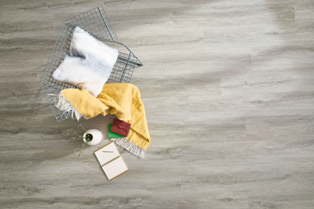 winylowe panele imitujące naturalne drewno, krzesło z drutu, poduszka, koc, wazon z kwiatami, notes, ołówek