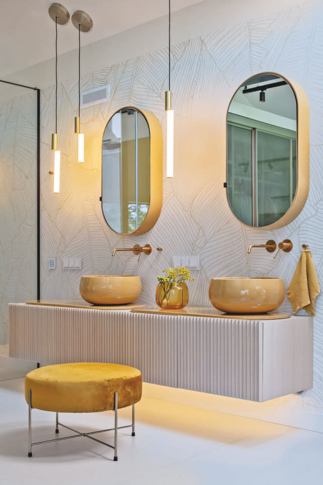 żółte umywalki i złote lustra i baterie w łazience 