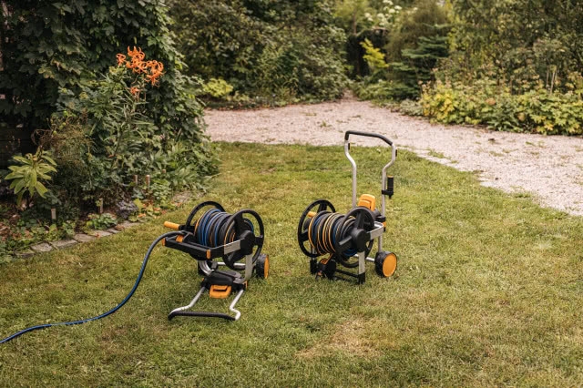 wózek z wężem, trawa, krzewy ozdobne, drzewa, ścieżka