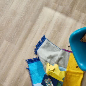 winylowe panele imitujące naturalne drewno, kolorowy koc, niebieski fotel, zabawka, notesy