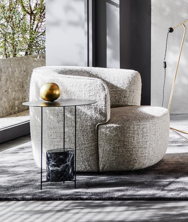 Masywny fotel w salonie z tkaniny boucle