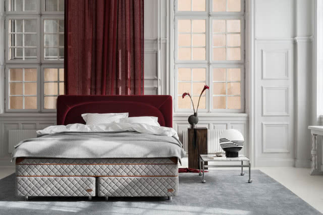 duże łóżko w sypialni, bordowa zasłona, sztukateria na ścianie, duże okna, stolik nocny