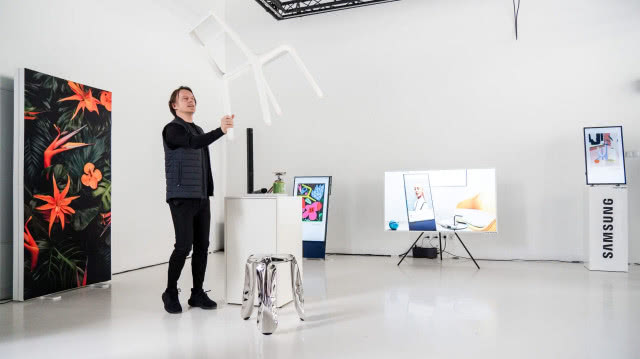 wystawa, mężczyzna podnosi lekkie krzesło