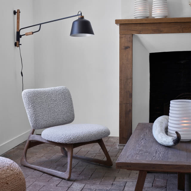 Szary, minimalistyczny fotel w salonie z tkaniny boucle