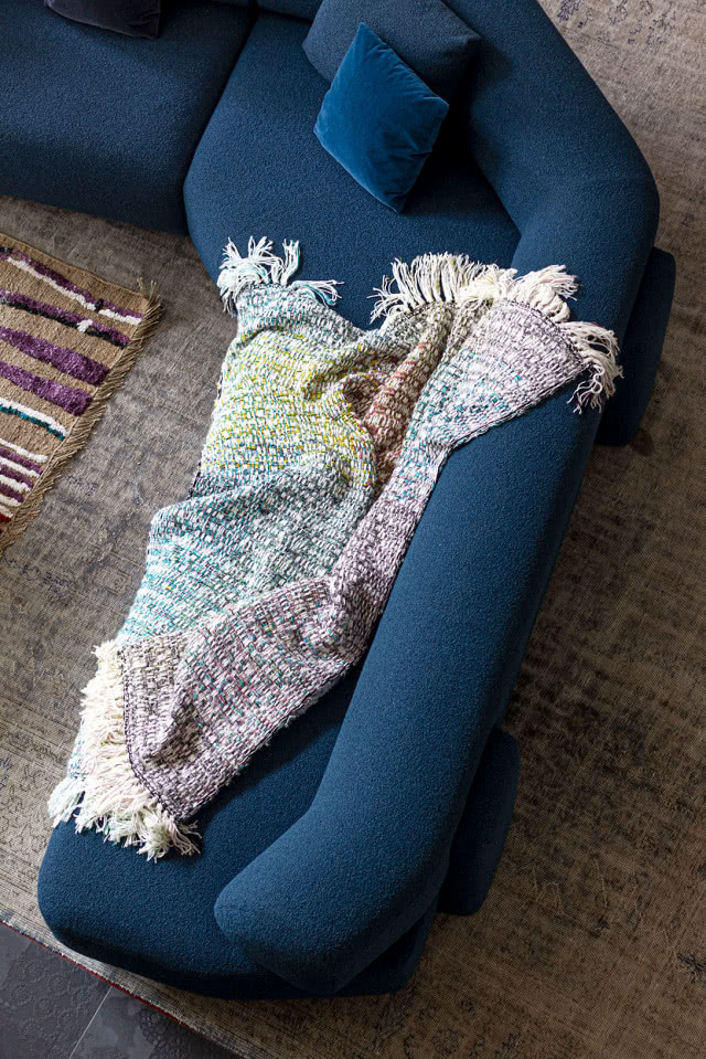 Niebieska sofa z narzutą z tkaniny boucle