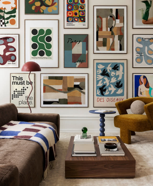 kolorowe obrazy  rozwieszone nieregularnie i gęsto na całej ścianie