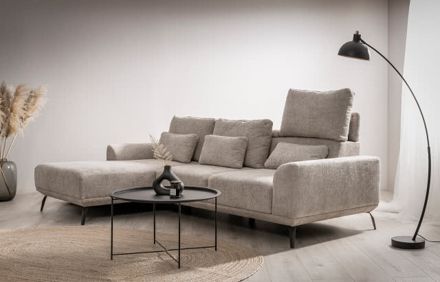 narożnik w kształcie litery L, lampa podłogowa, stolik kawowy, wazon z gałązką paprotki, zapachowa świeca, dywan