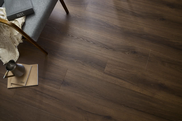 panele winylowe ciemne, krzesło, koc, notesy, książka, dzbanek