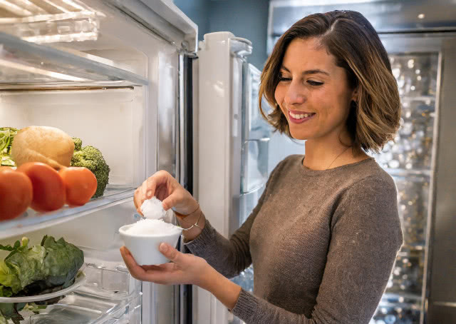 kobieta wkłada do lodówki miseczkę z solą