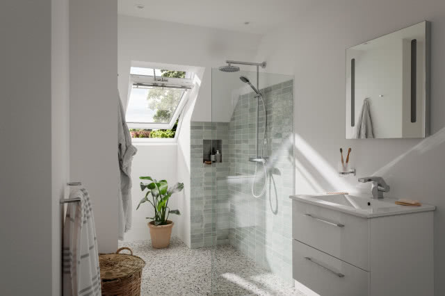 łazienka, okno dachowe, kabina prysznicowa, deszczownica, lustro, umywalka, kwiat w doniczce, kosz wiklinowy na pranie, ręczniki