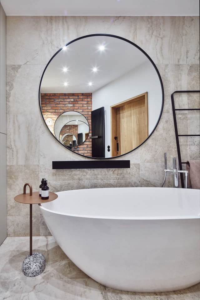 Loftowa łazienka z dużym lustrem i wanną wolnostojącą