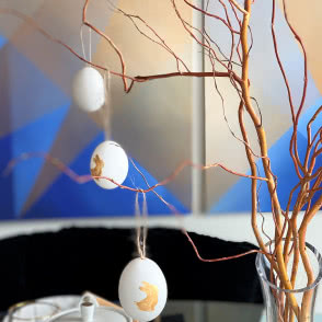 gałązki wierzby, jajka malowane zawieszone na gałązkach