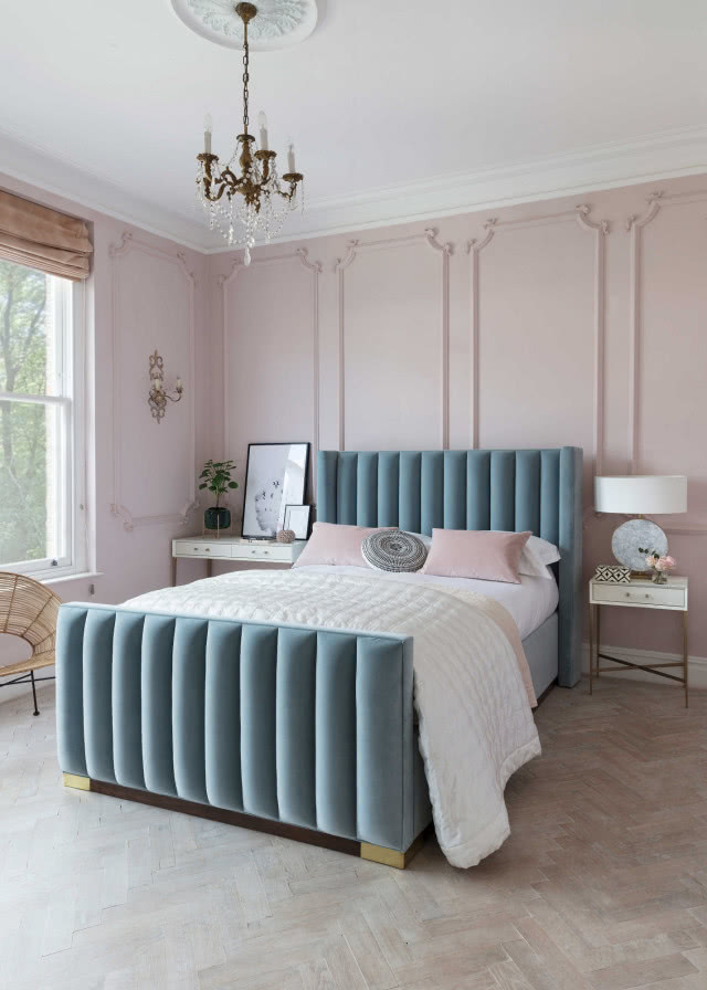 Пудрово-розовая спальня Изображение синей кровати в спальне на фоне бледно-розовой лепной стены