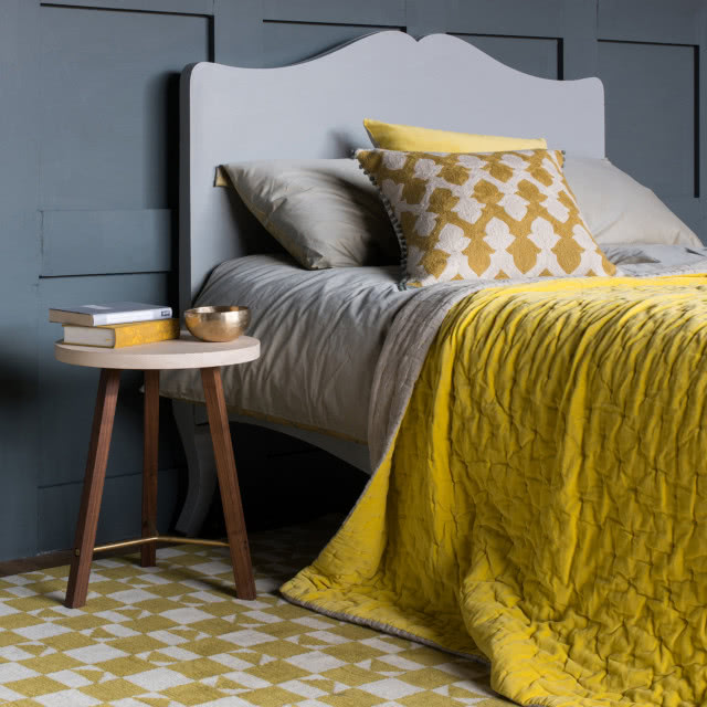 Изображение кровати в спальне с желтым покрывалом