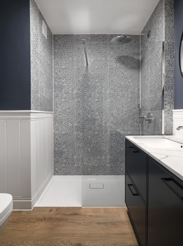 kabina prysznicowa błękitno-białe płytki, czarne meble łazienkowe, umywalka, lustro, deszczownica