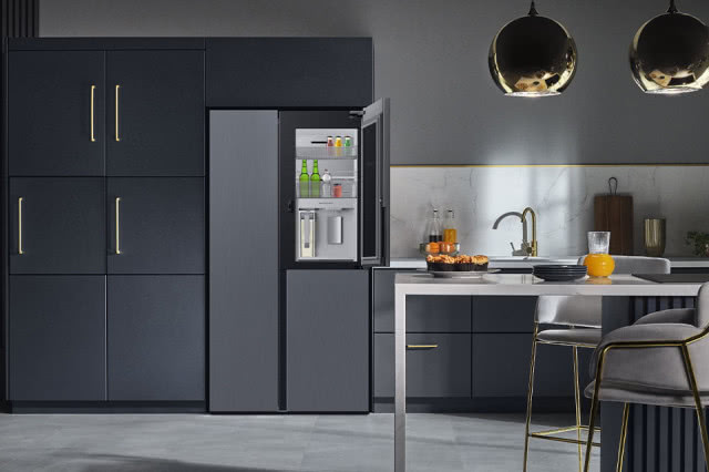 kostkarka do lodu, granatowe fronty kuchenne, biały blat, oświetlenie sufitowe, stołki barowe