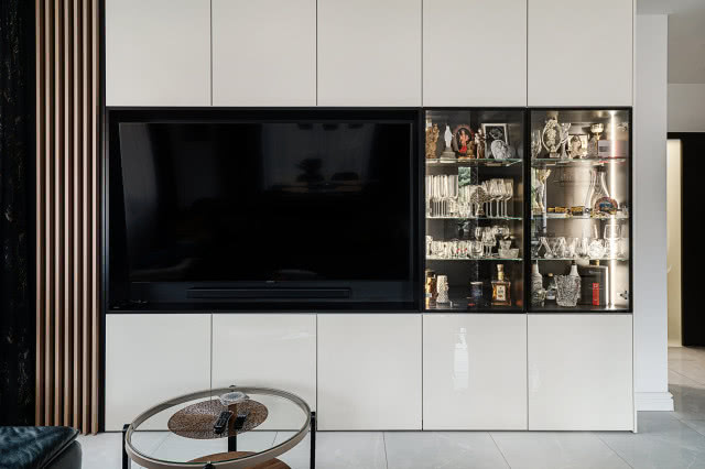 salon, duży telewizor, przeszklone półki, stolik kawowy