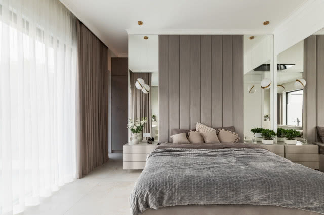 sypialnia z łóżkiem i tapicerowanym zagłówkiem na całą ścianę