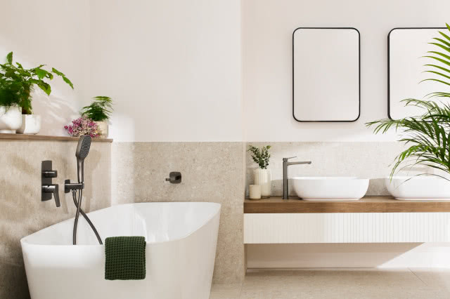 wanna wolnostojąca, dwie umywalki nablatowe, dwa prostokątne lustra w czarnej ramie, kwiaty