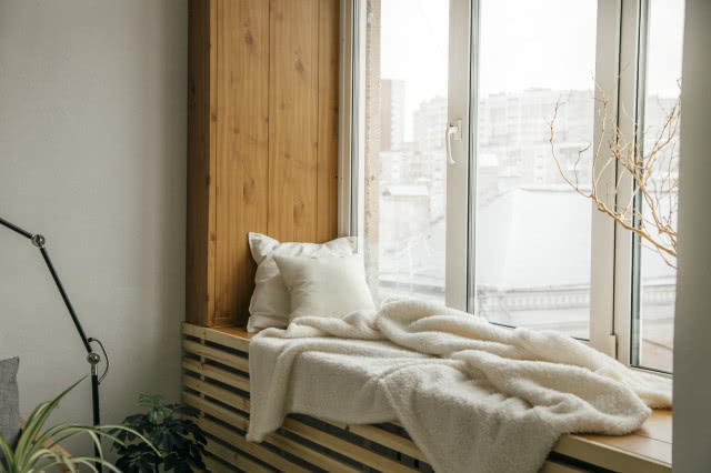 drewniany parapet z poduszką i kocem