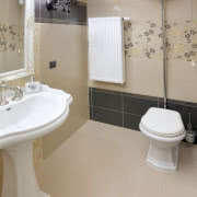 Beżowo-czarna łazienka na parterze pełni rolę...