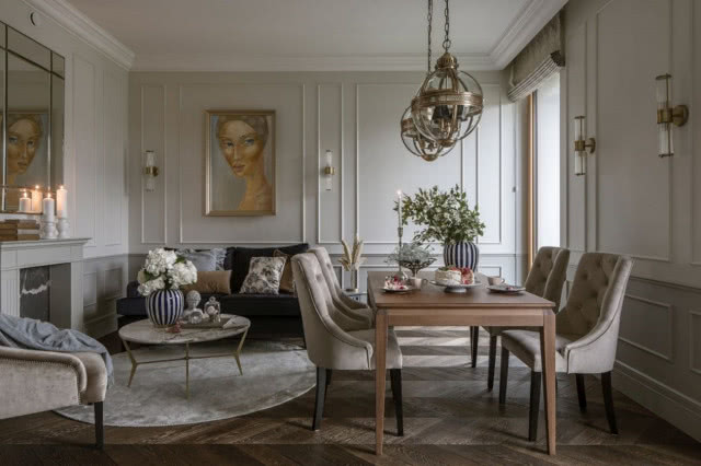 widok od strony stołu na sofę i obraz, ściana w prostych sztukateriach