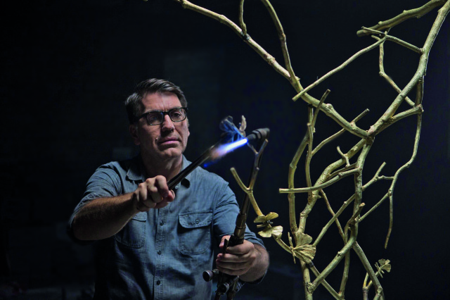 Michael Aram - wielokrotnie nagradzany amerykański artysta pochodzenia ormiańskiego, który tworzy luksusowe przedmioty. W czasie podróży do Indii w wieku 25 lat zafascynowała go bogata tradycja rzemiosła i wielowiekowe techniki obróbki metalu.  W swojej pracy łączy różne dziedziny sztuki. Czerpie inspiracje z przyrody, mówiąc, że natura jest jego największą muzą. Michael Aram, artysta i zapalony przedsiębiorca, osobiście stoi za każdym projektem. Przedmioty wykonuje ręcznie,  więc nie ma dwóch idealnie takich samych.