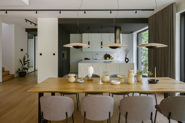 Jadalnia z dużym, drewnianym stołem i lampami wiszącymi