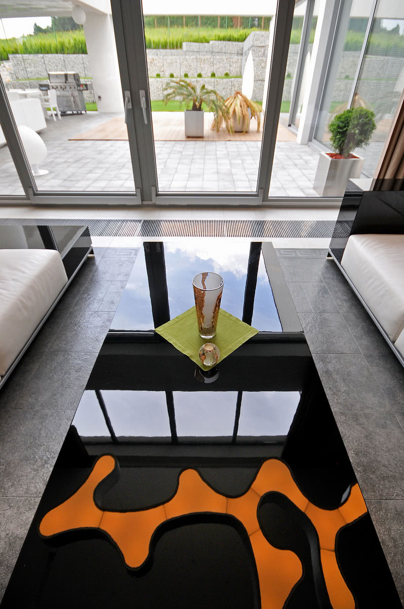 W blacie stolika kawowego z czarnego szkła...