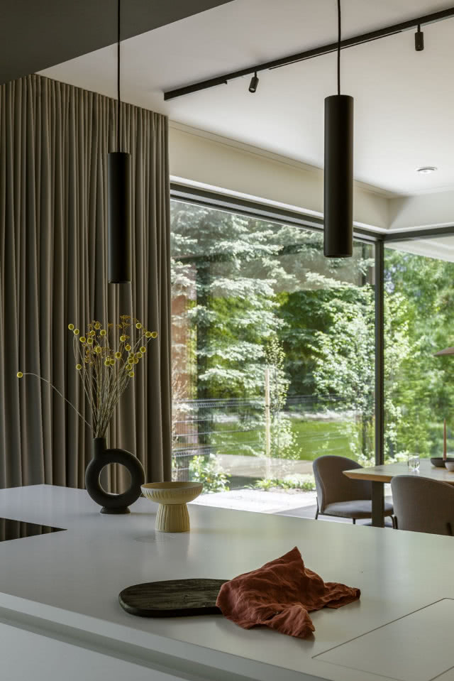 Biała wyspa kuchenna z widokiem na ogród