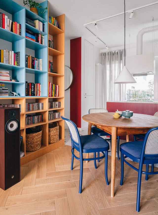 W mieszkaniu musiało znaleźć się miejsce na obszerny księgozbiór i kolekcję płyt. Wykonane na zamówienie regały pozwoliły pomieścić wszystkie te skarby. W wysokiej zabudowie z białym frontem i czerwonym bokiem ukryto pralkę, dzięki czemu zyskano cenną przestrzeń w niedużej łazience.