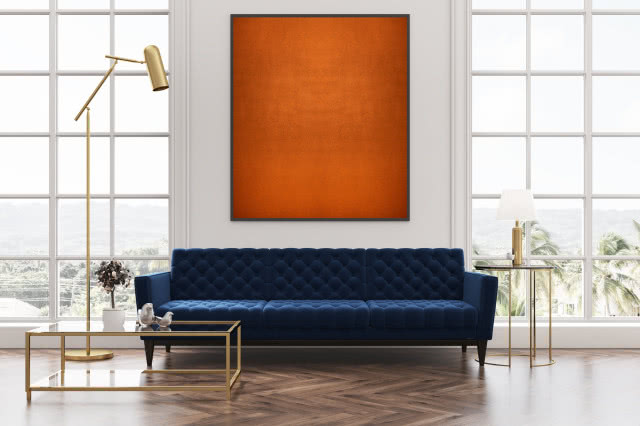 farba o efekcie miedzi, granatowa sofa, prostokątny stolik kawowy ze złotym stelażem, złota lampa podłogowa, duże okna, okrągły stolik, lampa stojąca na stoliku, figurki ptaków, kwiat