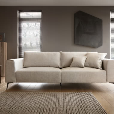 Sofa Loft - wdzięk i klasa, stolik na którym stoi lampa, dywan, żaluzje