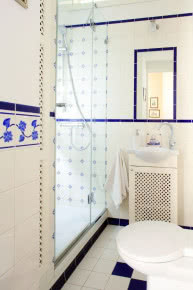 Łazienka w klasycznym stylu - biała z granatowymi akcentami.