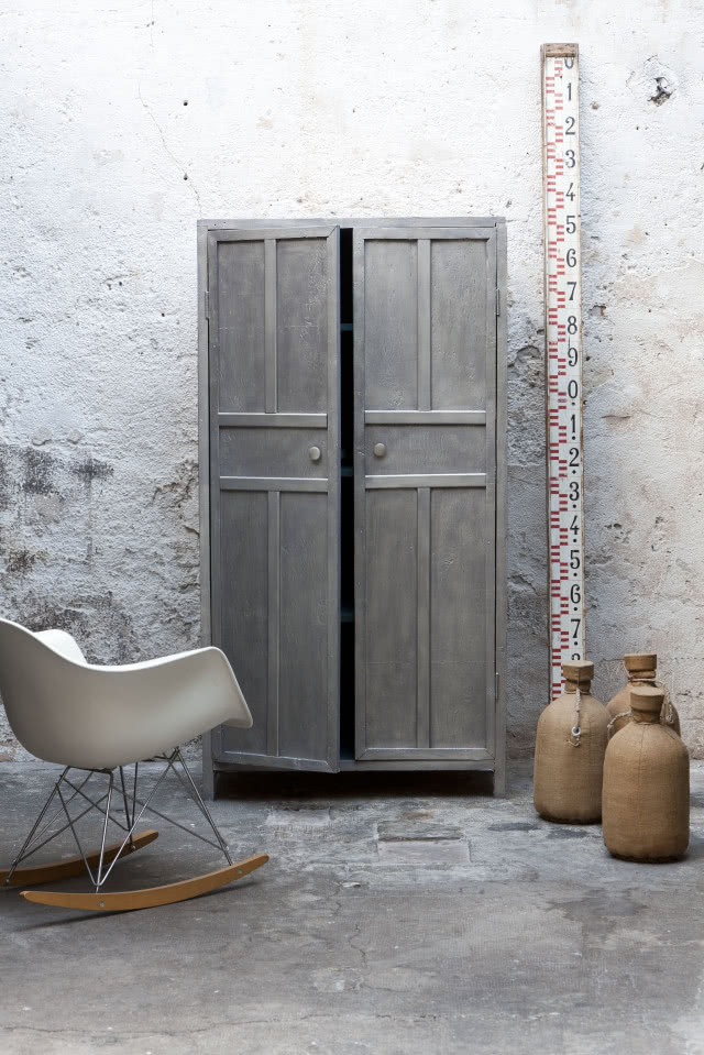 odnowiona szafa dwudrzwiowa w odcieniu szarym, biały fotel bujany, dzbany