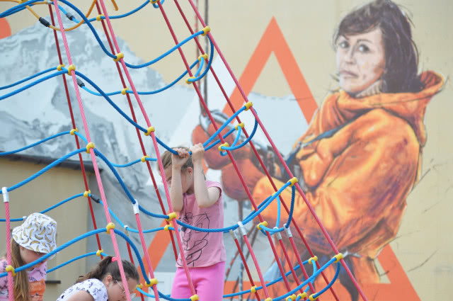 "Pajączek" dla dzieci na tle muralu Wandy Rutkiewicz