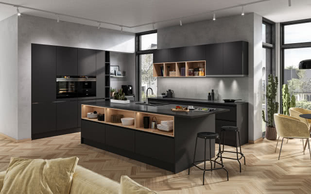 wyspa kuchenna z czarnym blatem, stołki barowe, czarne meble kuchenne, bateria zlewozmywakowa, czarny zlewozmywak, podświetlane półki z drewna naturalnego, drewniana podłoga ułożona w jodełkę