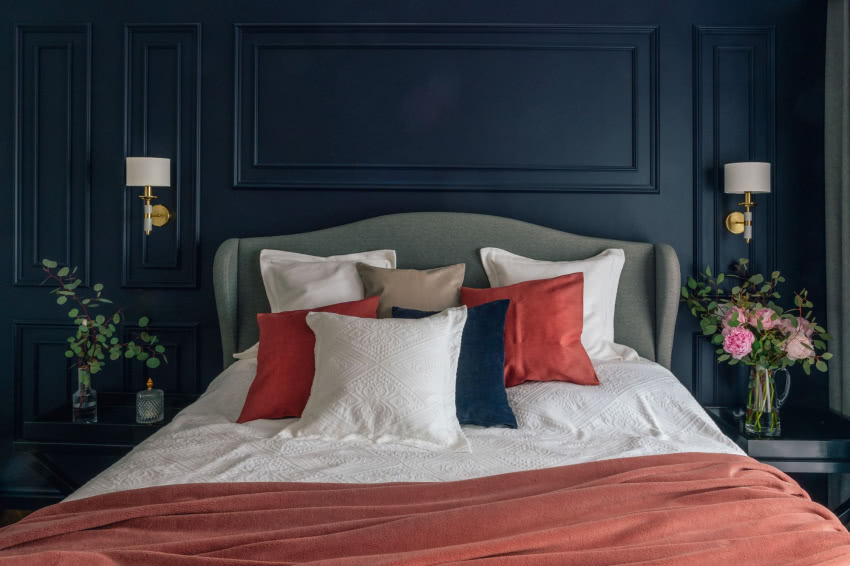 Po obydwu stronach łóżka z tapicerowanym...