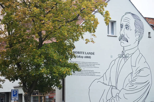 Drzewo na tle muralu Moritza Landego